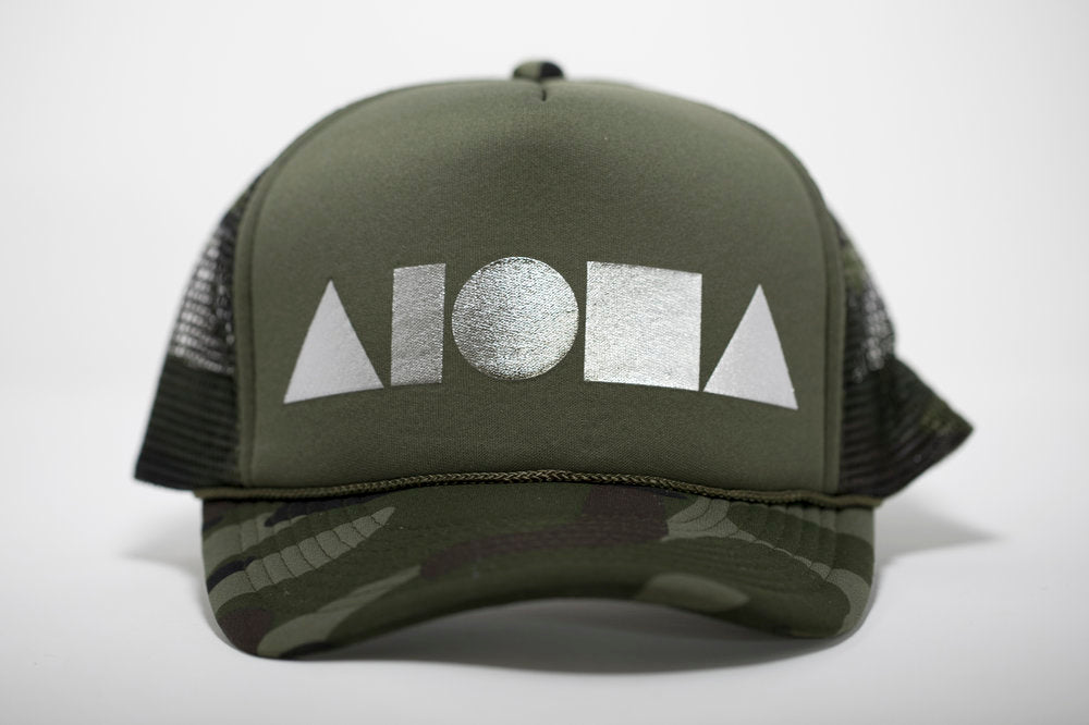 Adult foam trucker hat. Military green camo brim. Military green foam front panels with silver foil print Aloha Shapes® logo. Military green mesh back panels. 